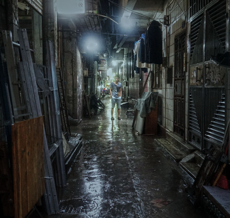 城中村雨天幼巷坐着等客